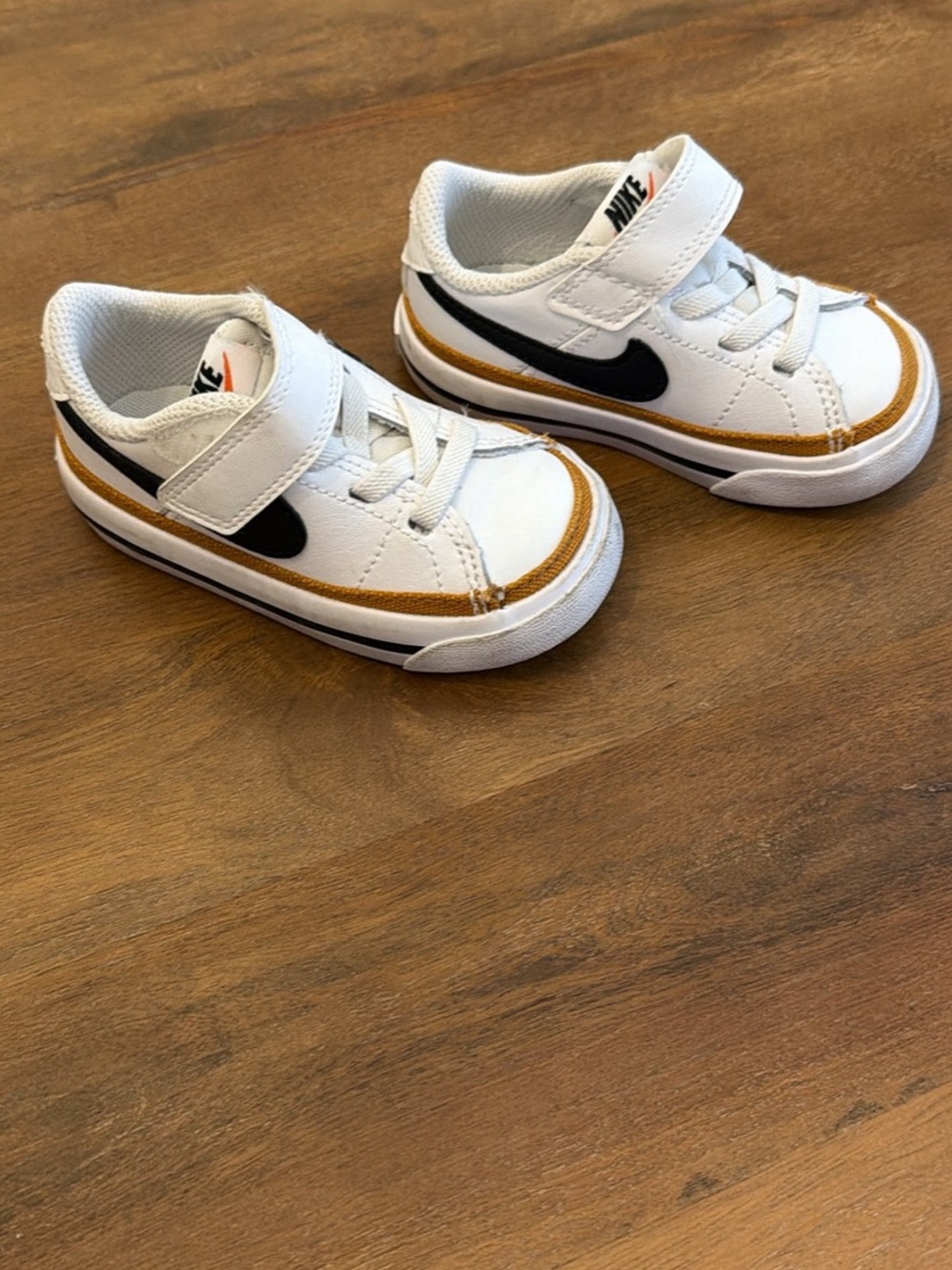 Nike Kids White Sneakers with Black Swoosh and Gold Trim